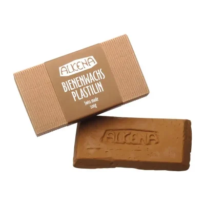 אריזת המוצר עם הכיתוב ALKENA - BIENEWACHS PLASTILIN. swiss made. 20 g. ולצידו הפלסטלינה בצורת מלבן בצבע חום.