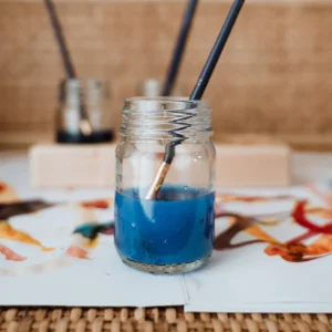 צנצנת זכוכית ובתוכה צבעי מים עם מכחול