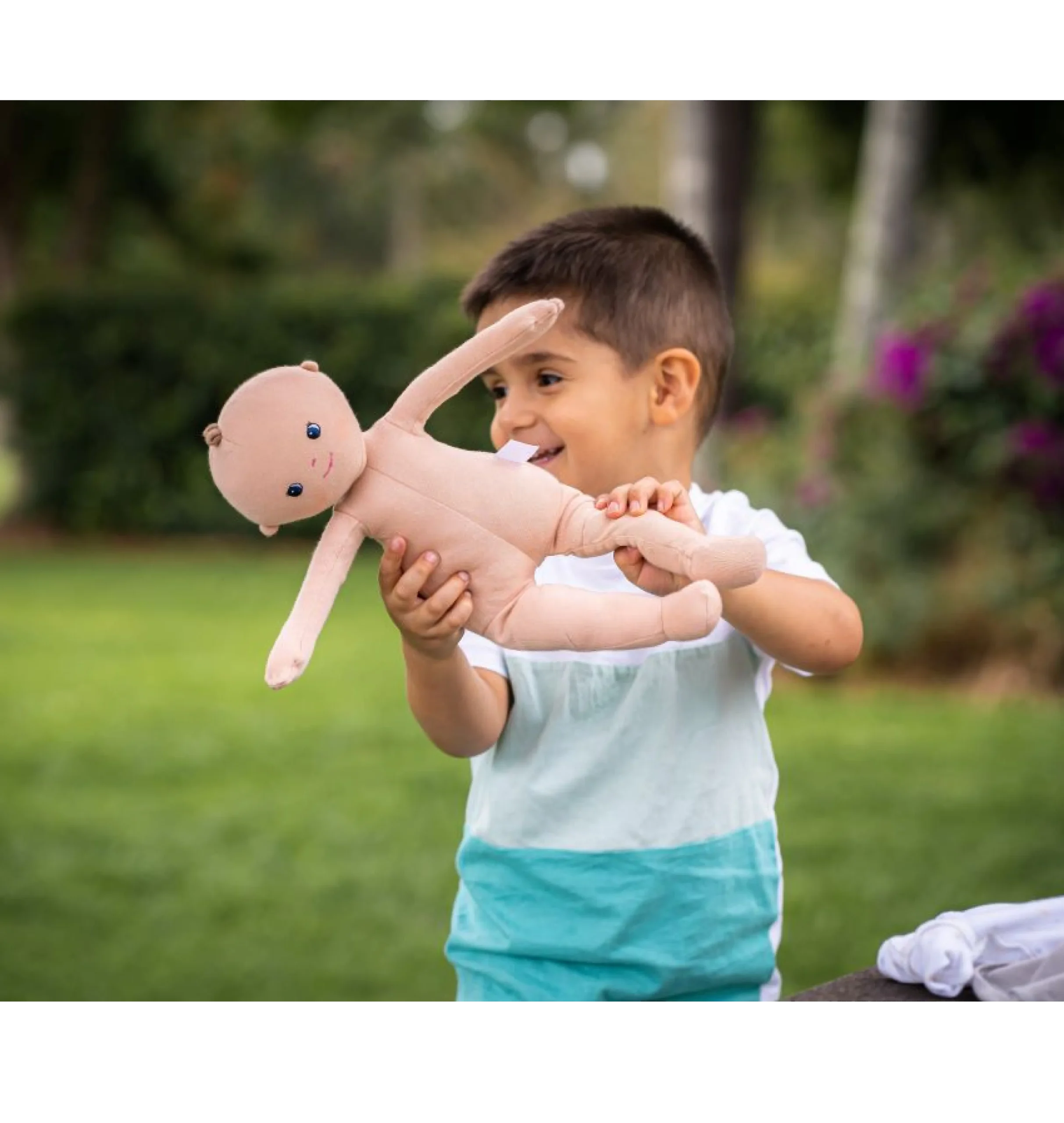 ילד משחק בבובת התינוק ללא הבגדים