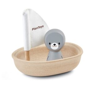 סירת עץ עם בובת כלב ים מעץ ודגל לבן עם הכיתוב plan toys