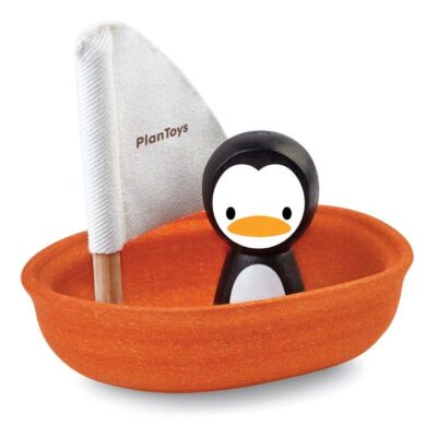 סירת עץ אדומה עם פינגווין ודגל לבן עם הכיתוב plan toys
